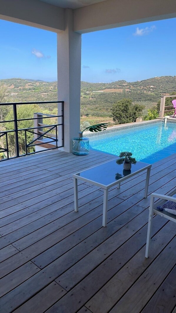A wooden deck with a pool and a view of hills. - House (Cargèse)