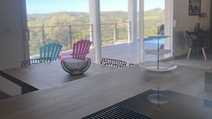A modern dining area with a large table, chairs, and pendant lights. - House (Cargèse)
