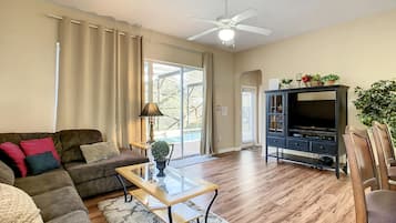 Relax in this spacious living room with a large window, comfortable sofa, and flat-screen TV.