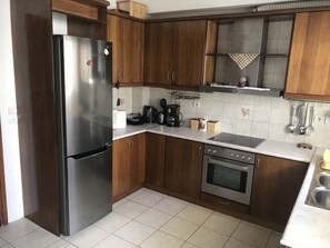Una cocina moderna con armarios de madera, electrodomésticos de acero inoxidable y salpicadero de azulejos.