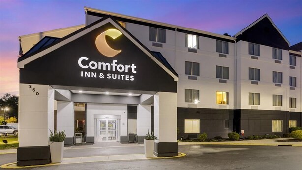 A Comfort Inn & Suites hotel with a modern design, featuring a prominent logo, a well-lit entrance, and a parking lot. - Comfort Inn & Suites (Mount Laurel)
