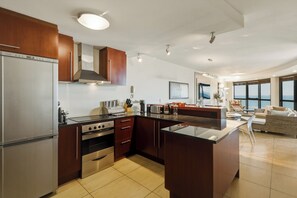 Une cuisine moderne dotée d’appareils électroménagers en acier inoxydable, d’armoires en bois et d’un grand îlot central.