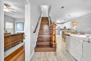 Staircase leads to an upper level, flanked by a handrail and a light fixture.
