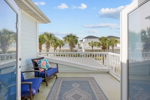 Enjoy the serene view of the neighborhood from this balcony with a glass door leading to the interior.
