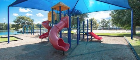 Une aire de jeux avec un toboggan et des structures d’escalade.