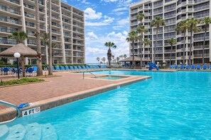 Un espace piscine d’hôtel avec un indicateur de profondeur de 1,2 mètre, des chaises longues et des palmiers.