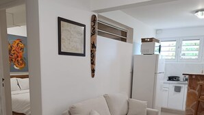 A modern living room with a beige sofa, a framed map, and a decorative wall piece. - Balisier Suite, sea and pool view. (Schoelcher)