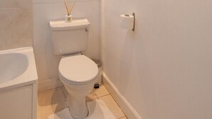 A small, clean bathroom with a toilet, sink, and mirror. - An elegant and spacious two-bedroom apartment. Sleeps 4. (Edinburgh)