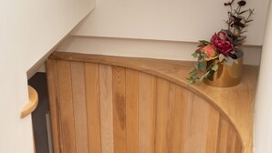 Eine Holzspirale mit Metallgeländer, die zu einer oberen Etage führt.