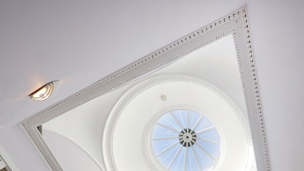 A high-ceilinged room with a central skylight and a staircase with white railings and wooden steps. - A spacious open plan apartment, in an unbeatable city-centre location. Sleeps 4. (Edinburgh)