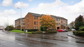 A multi-story residential building with a brick facade and a flat roof.