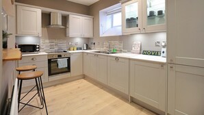 A modern kitchen with white cabinets, a microwave, a sink, and a window with a view of the outside.