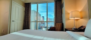 Enjoy a city view from the comfort of this room, featuring a large bed and a convenient nightstand with a lamp and telephone.