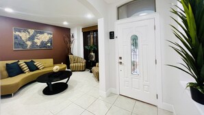 A modern living room with a sofa, armchairs, a coffee table, and a large potted plant. - Luxury Home❤️Las Villitas❤️Close to the Mall and Airport ❤️ (McAllen)