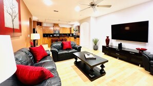 A modern living room with a black leather sofa, a coffee table, and a flat-screen TV. - Luxury Home❤️Las Villitas❤️Close to the Mall and Airport ❤️ (McAllen)