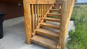 Eine Holztreppe mit Metallgeländer, die zu einer oberen Ebene führt.