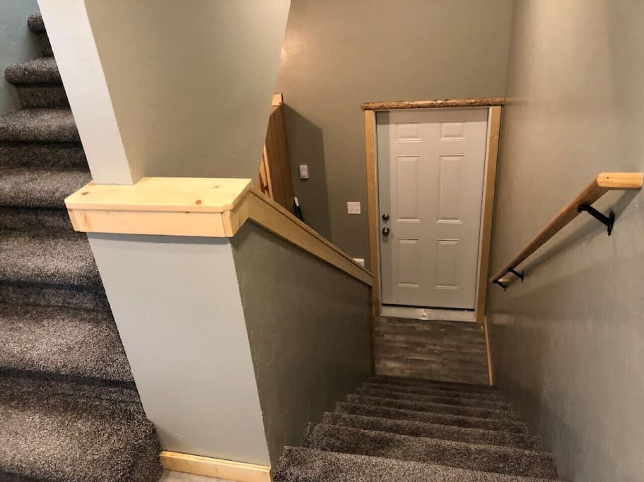 A staircase with carpeted steps leading to a door.