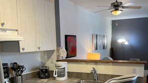 Una cocina moderna con estufa, fregadero y ventilador de techo.