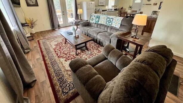 A living room with a sofa, coffee table, and a patterned rug.