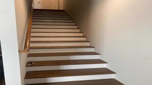Una escalera con escalones de madera y peldaños blancos.