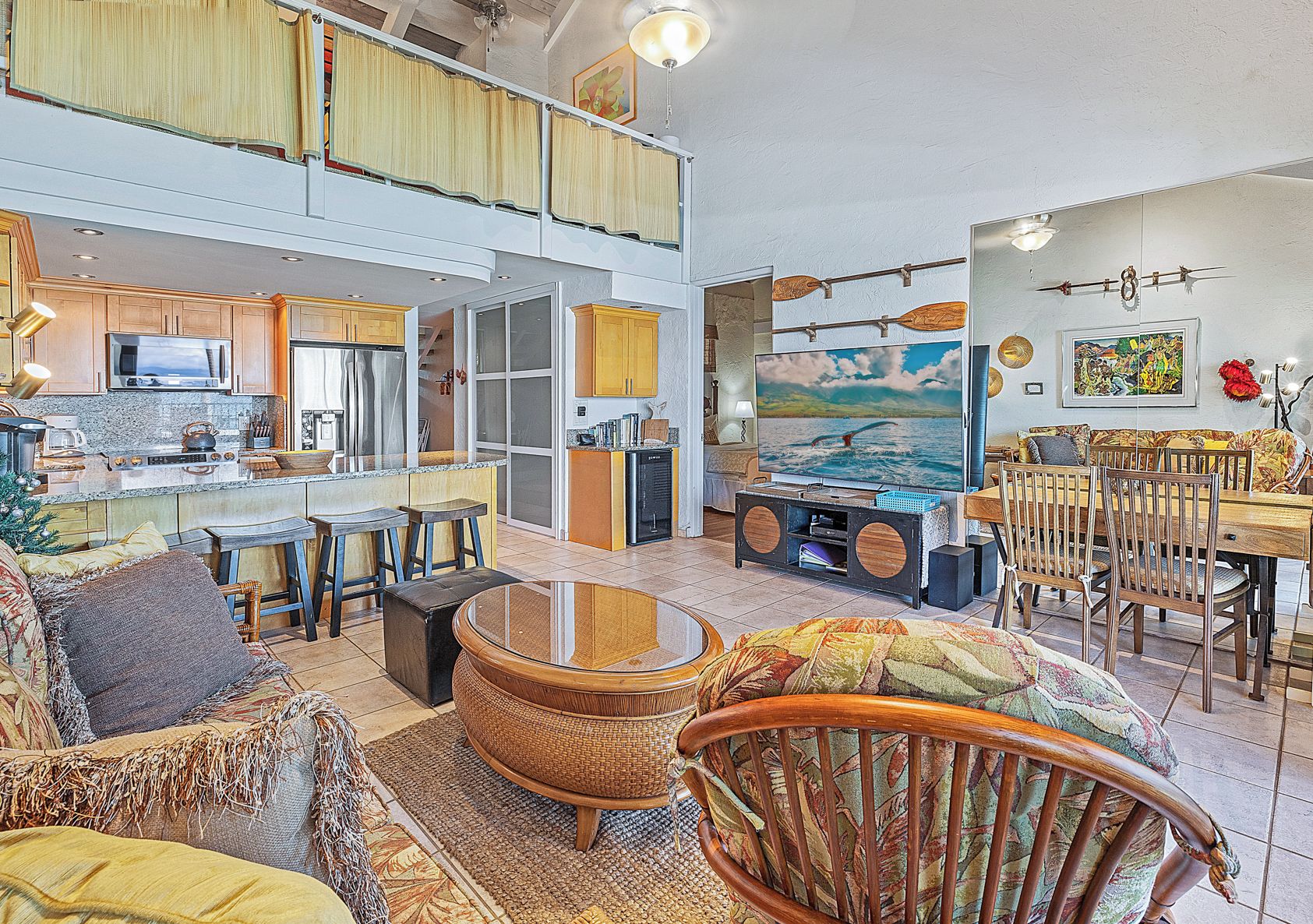 A spacious living area with a kitchen, dining space, and a large TV.