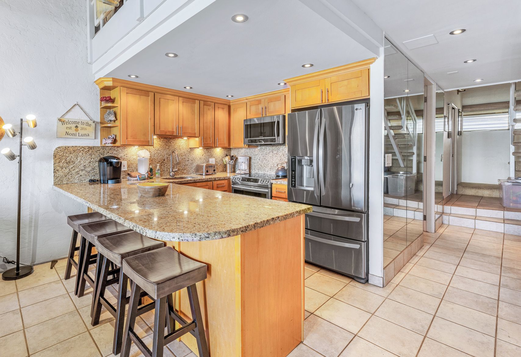 A modern kitchen with granite countertops, stainless steel appliances, and wooden cabinets.
