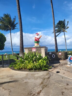 Ein Rettungsschwimmturm mit einer Weihnachtsmann-Statue auf dem Dach, umgeben von Palmen und Blick auf den Ozean.