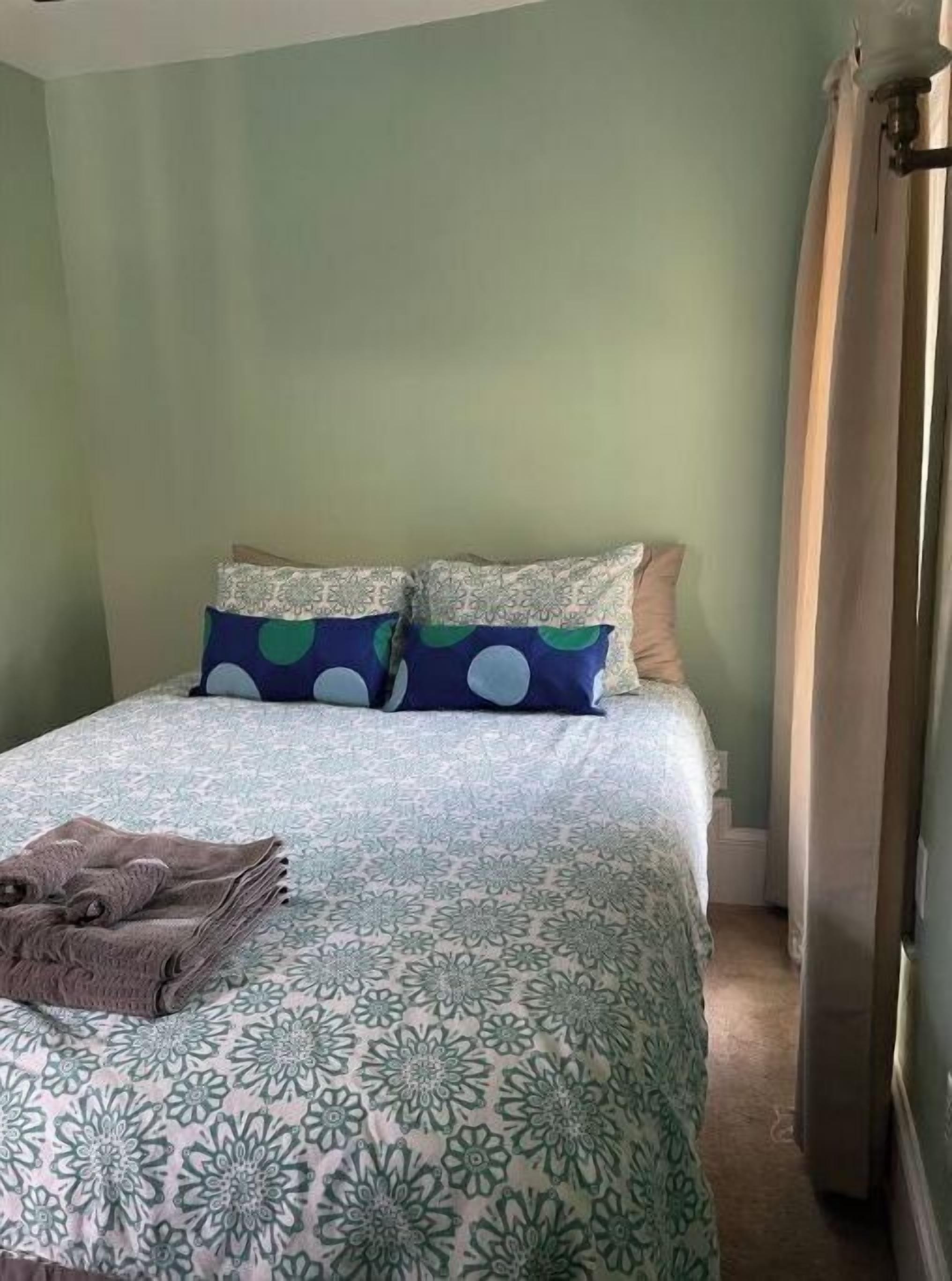 A bedroom with a bed, pillows, and a folded towel.
