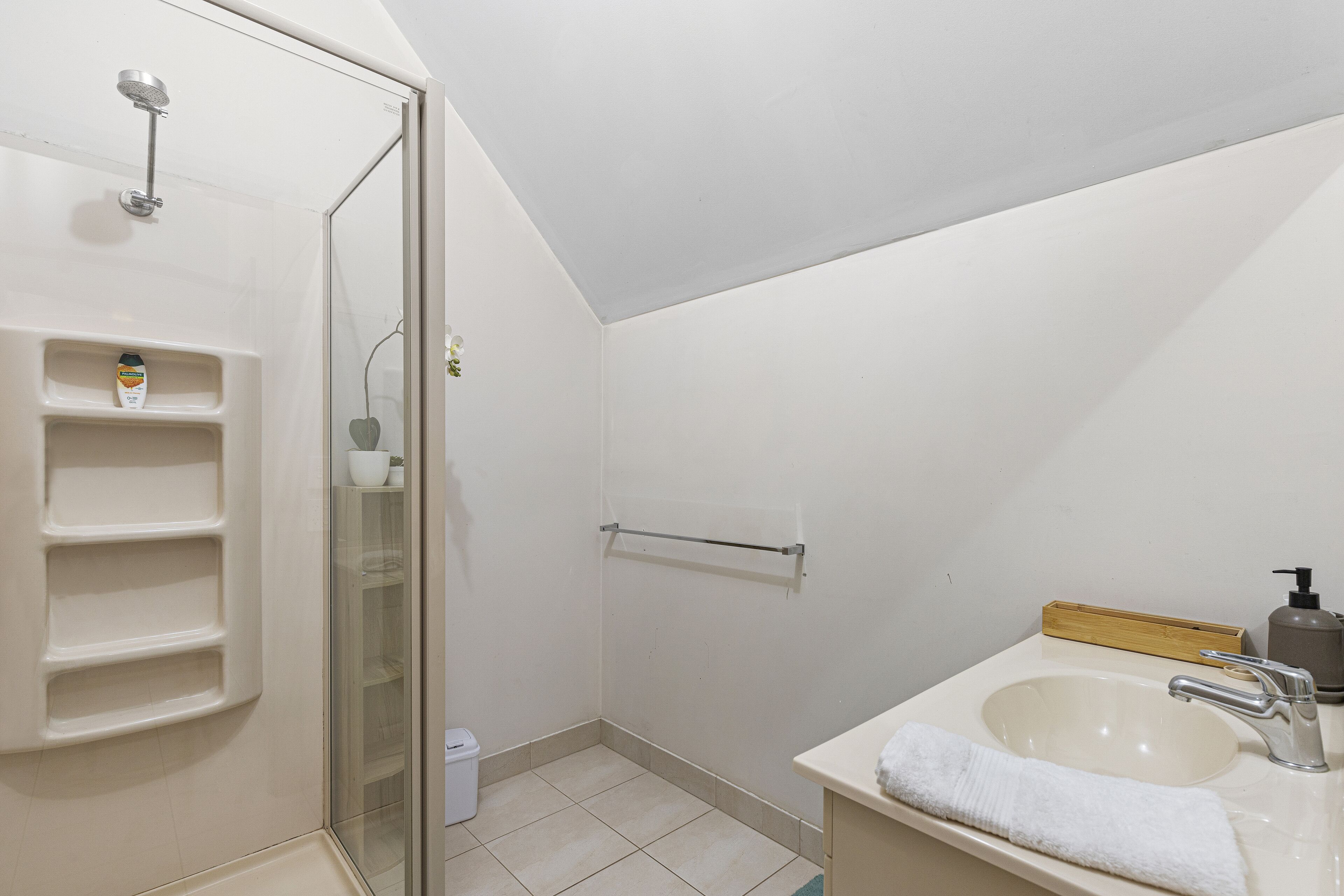 A bathroom with a shower, a sink, and a toilet.