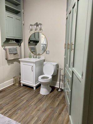 Een bad/douchecombinatie, een haardroger, handdoeken, zeep