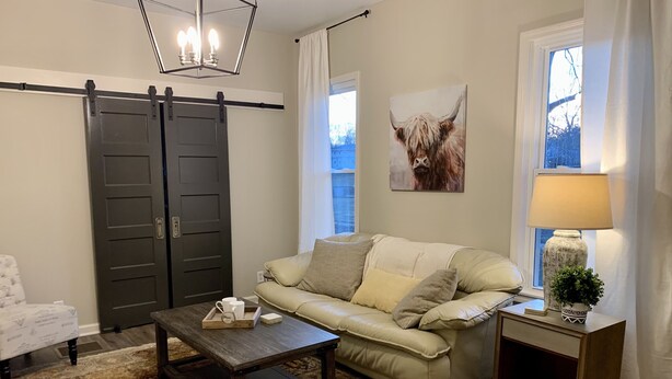 A living room with a sofa, coffee table, and a lamp.