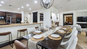 Una cocina moderna con armarios oscuros, un refrigerador de acero inoxidable y un microondas.