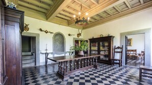 A room with a checkered floor, a wooden table, a chandelier, and a bookshelf. - Villa Poggio Cherici by MMega (Rignano sull'Arno)