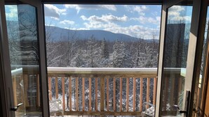 A balcony with a wooden railing and a bench, overlooking a snowy landscape with trees and mountains. - Beautiful Mountain House with amazing views 11min from Mountain Creek & Warwick (Vernon Township)