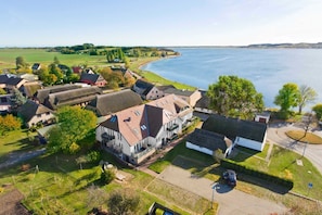 An aerial view of a coastal village with houses, a road, and a body of water. - Courtyard Residence - quiet location with a garden, near the sea - Höftresidenz (Middelhagen)
