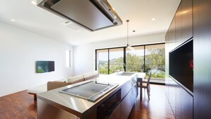 A modern kitchen with a large island, stainless steel appliances, and a view of the outdoors. - E-horizon Resort Premium SESOKO B (Motobu)