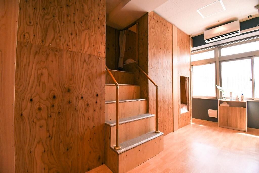 A wooden staircase with metal railings leading to a room with a large window and a built-in desk.