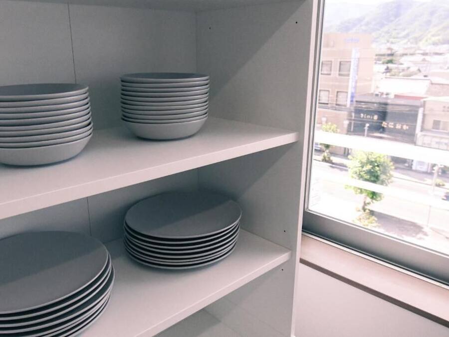 A shelf with stacks of plates.