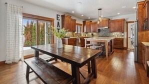 Una cocina moderna con armarios de madera, una isla central y un comedor con banco.