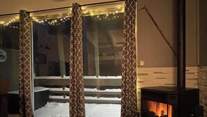 A cozy room with a fireplace, patterned curtains, and a view of a snowy outdoor area. - Renovated & spacious 2 bed/2 bath Condo with Mountain Views - near Eagle Lodge  (Mammoth Lakes)