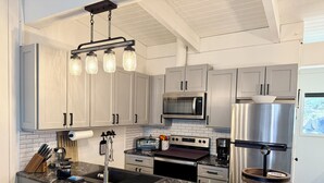 A modern kitchen with white cabinets, a stainless steel refrigerator, a microwave, a stove, and a coffee maker. - Renovated & spacious 2 bed/2 bath Condo with Mountain Views - near Eagle Lodge  (Mammoth Lakes)