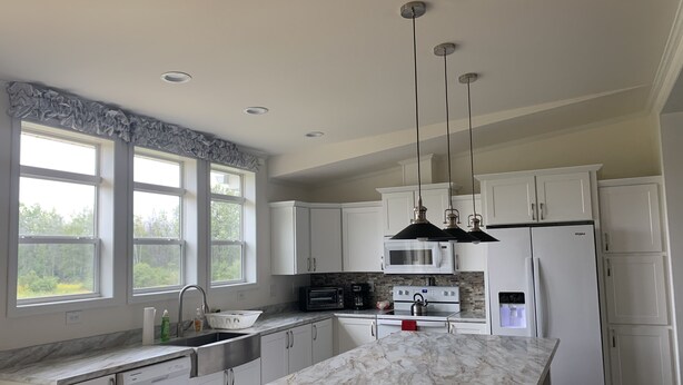 A modern kitchen with white cabinets, a marble countertop, and a built-in oven. - Lunker House By the Bay- Rural, Contemporary and Spacious-Moments from Downtown  (Sturgeon Bay)