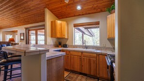 Une cuisine avec des meubles de rangement en bois, un plan de travail et une fenêtre.
