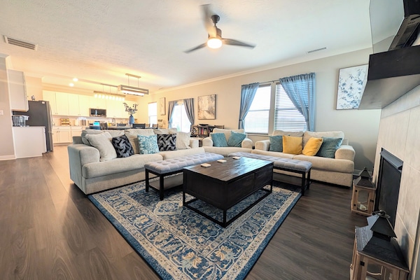 Great room with 65" smart tv, ceiling fan, gas fireplace and throw blankets
