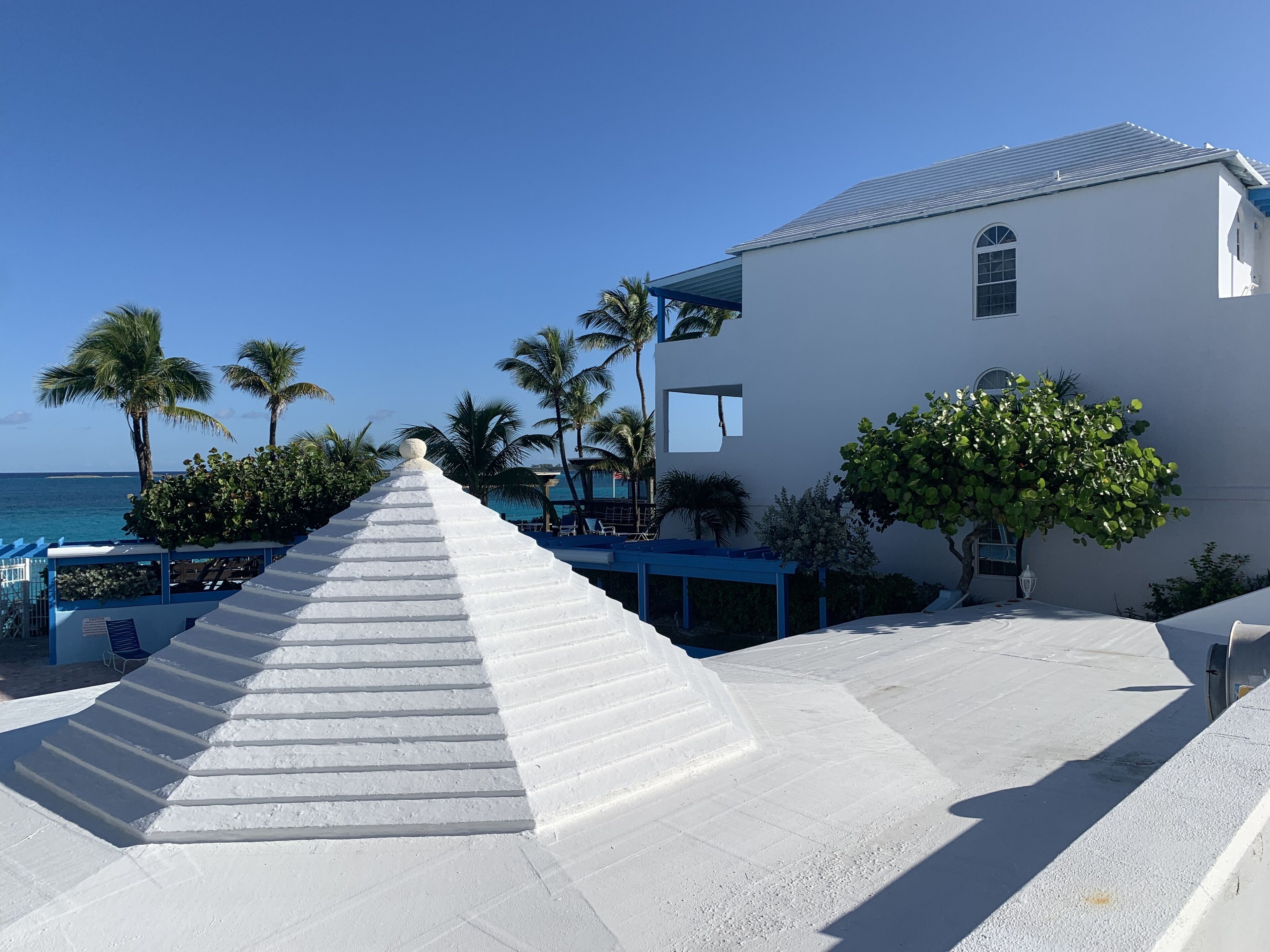 Un escalier menant à un bâtiment d’où l’on a une vue sur l’océan.