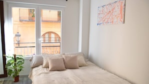 A bedroom with a bed, a potted plant, and a view of the outside balcony. - Stunning renovated 2-Bed Apartment in Valencia (València)