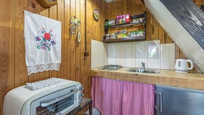Eine Küche mit Holzwänden, einem Herd, einer Spüle und einem Kühlschrank.
