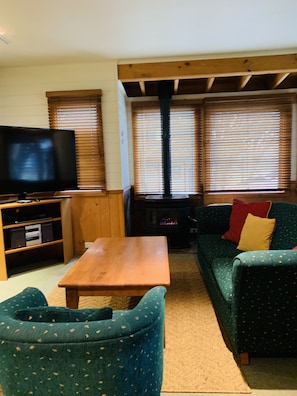 Un salon équipé d’une télévision, de meubles en bois, d’un canapé et d’une cheminée.
