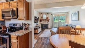 Eine moderne Küche mit Holzausstattung, Edelstahlgeräten und einer Küchenwand aus Stein.