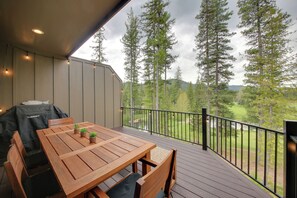 A wooden deck with a table and chairs, overlooking a forested area. - Elegant Priest Lake Townhome ~ 1 Mi From Lake (Priest Lake)
